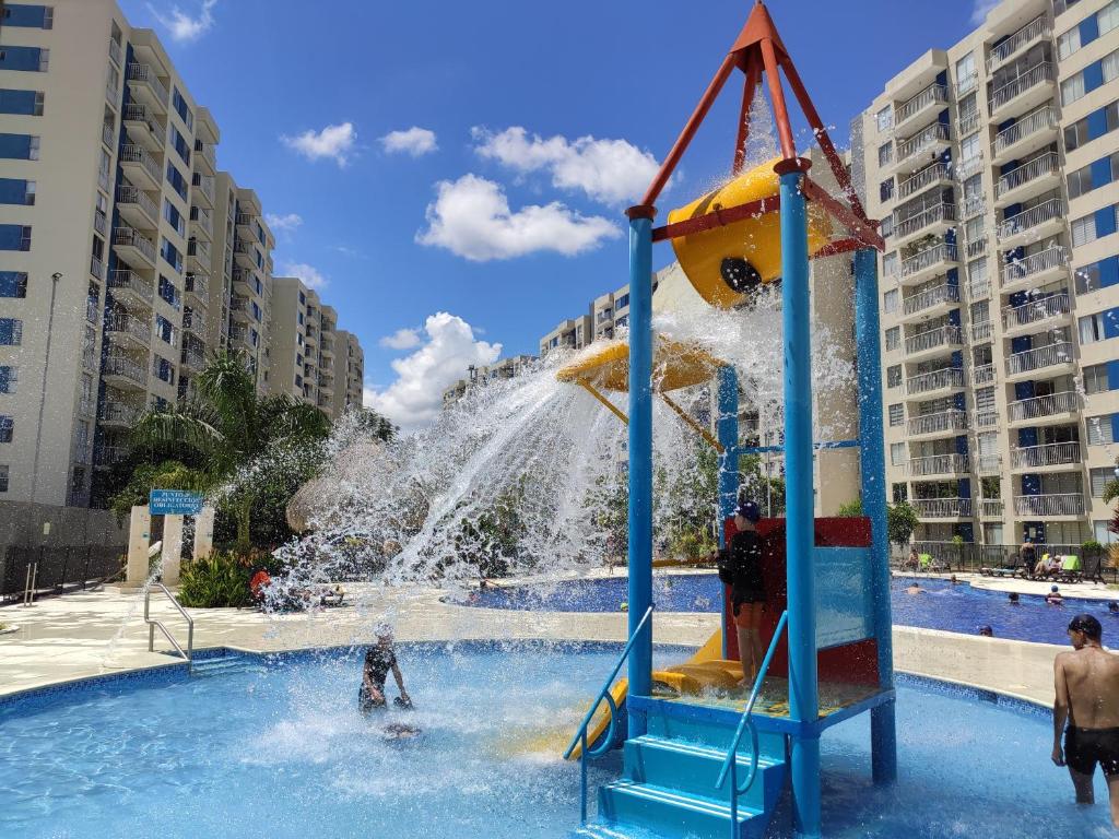 un garçon joue dans une fontaine dans un parc aquatique dans l'établissement Apartamento Vacacional en Ricaurte Cundinamarca, Entre Melgar y Girardot, à Ricaurte