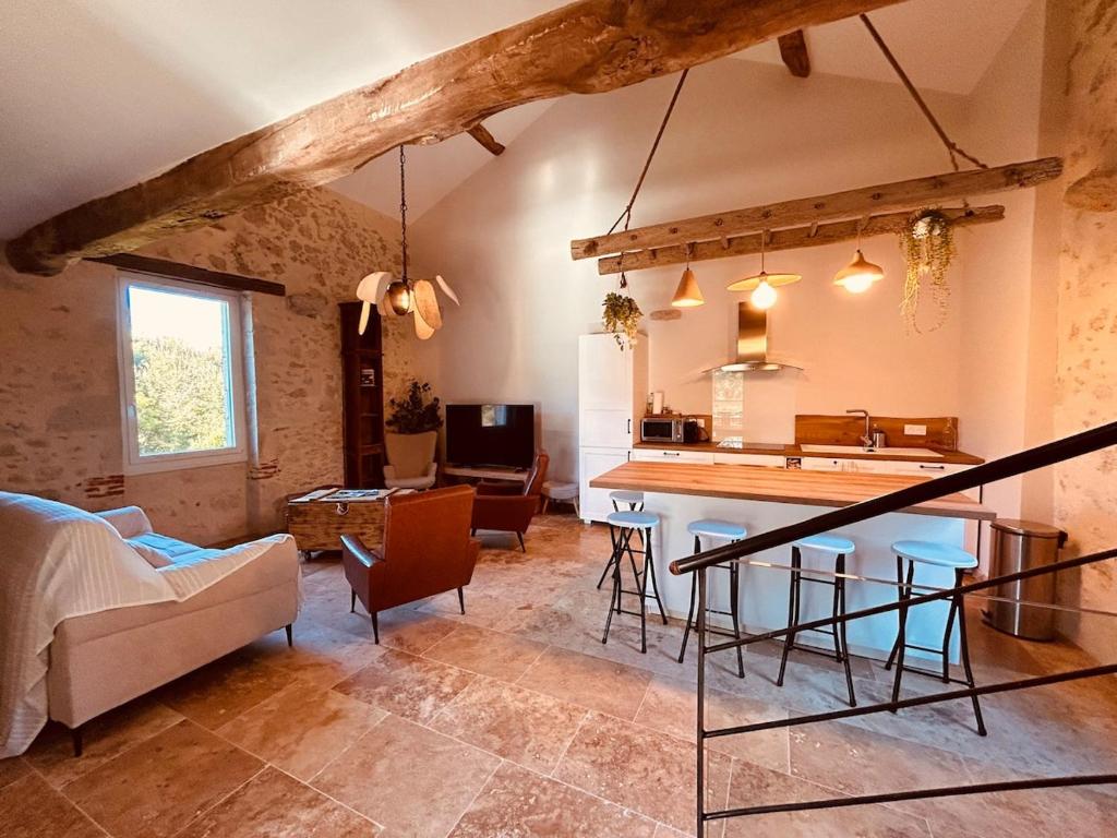 a living room with a kitchen and a table at Le Moulin de Toquedonnes Gîte insolite in Saint-Michel