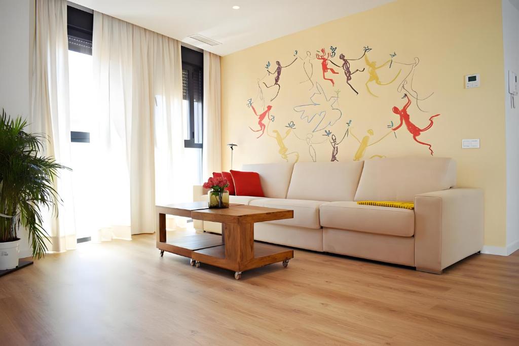 a living room with a white couch and a table at Pepe Lux Ático centro de Málaga in Málaga
