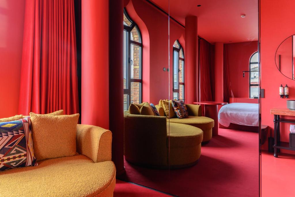 a red room with chairs and a bed and a mirror at BHB Boutique House in Macedo de Cavaleiros