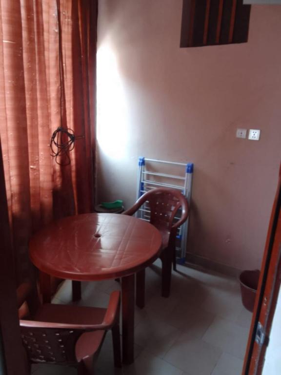 une table et des chaises en bois dans une pièce avec une table et une chaise dans l'établissement Apecsi, à Dakar