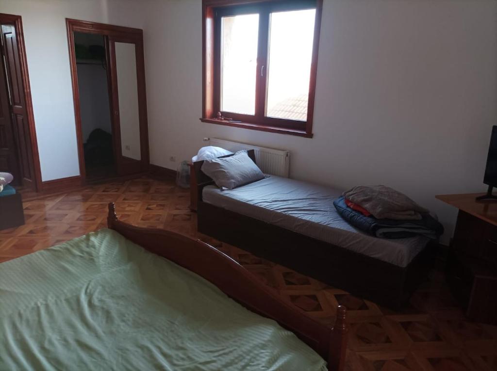 a room with two beds and a window at Casa de vacanta in Târgu Jiu