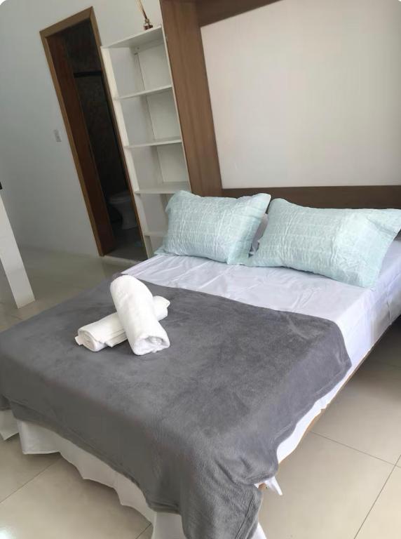 a large bed with two pillows on top of it at Residencial da Ju in Bombinhas