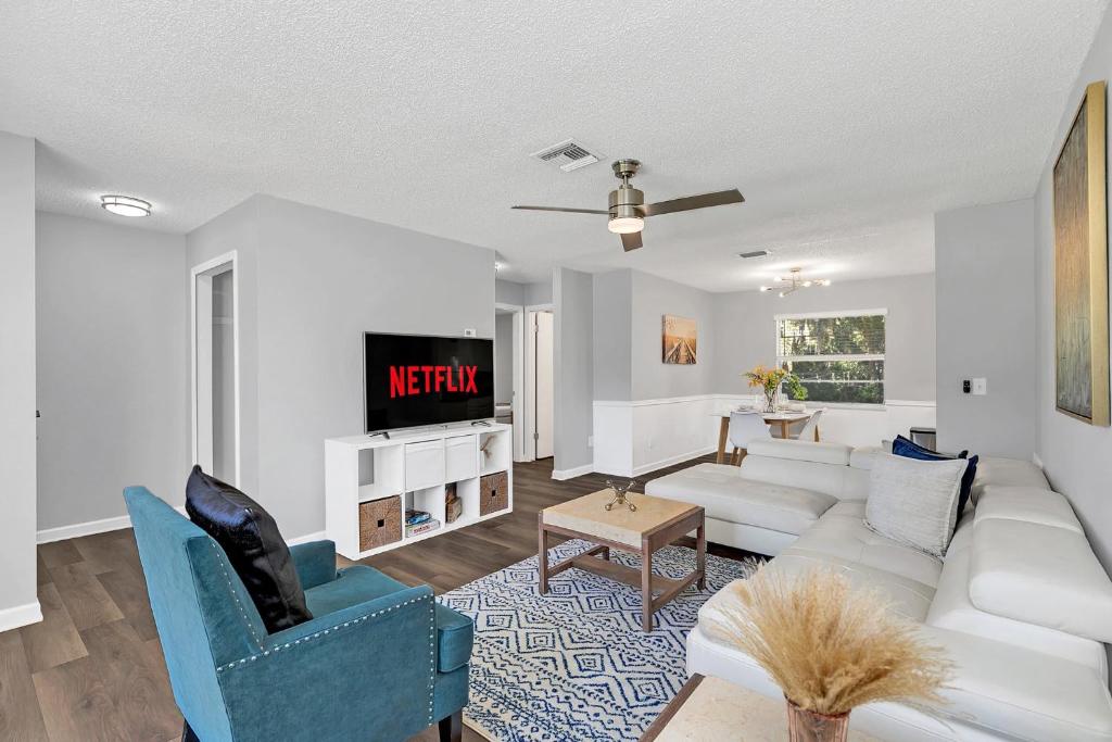 a living room with a white couch and a tv at Cozy Villa with Spacious Outdoor Space in Orange City
