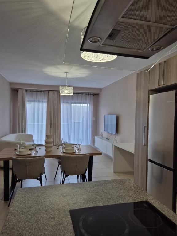 ヨハネスブルグにあるCorporate Luxury - Sandton, Rivoniaのテーブルと椅子のあるキッチンとリビングルーム