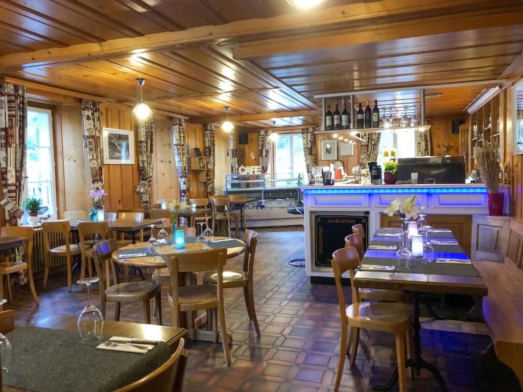 un ristorante con tavoli e sedie e un bar di Auberge de l'Ange ad Albeuve