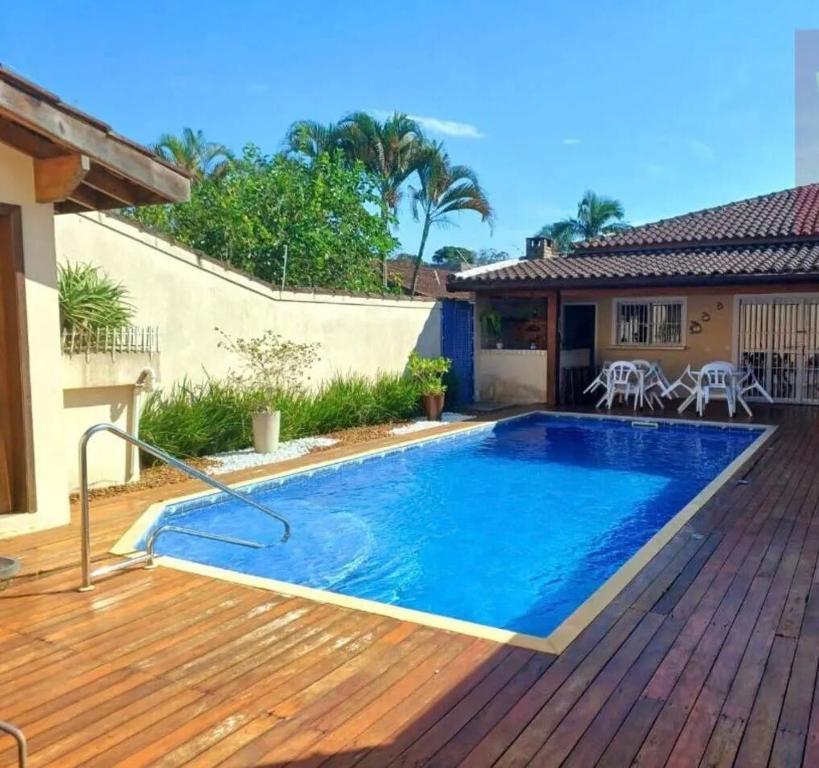 a swimming pool on a deck next to a house at House in Bertioga - Indaia in Bertioga