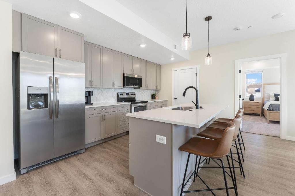 een keuken met een roestvrijstalen koelkast en barkrukken bij Heart and Sol condo in St. George