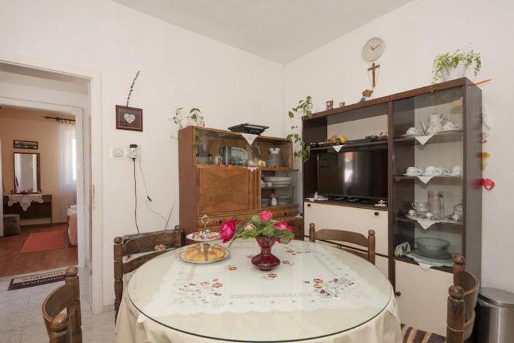 a room with a table with flowers on it at Two Bedroom Apartment with Terrace A1 in Splitska
