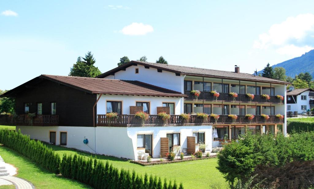 una gran casa blanca con techo negro en Hotel Alpenblick Berghof, en Halblech