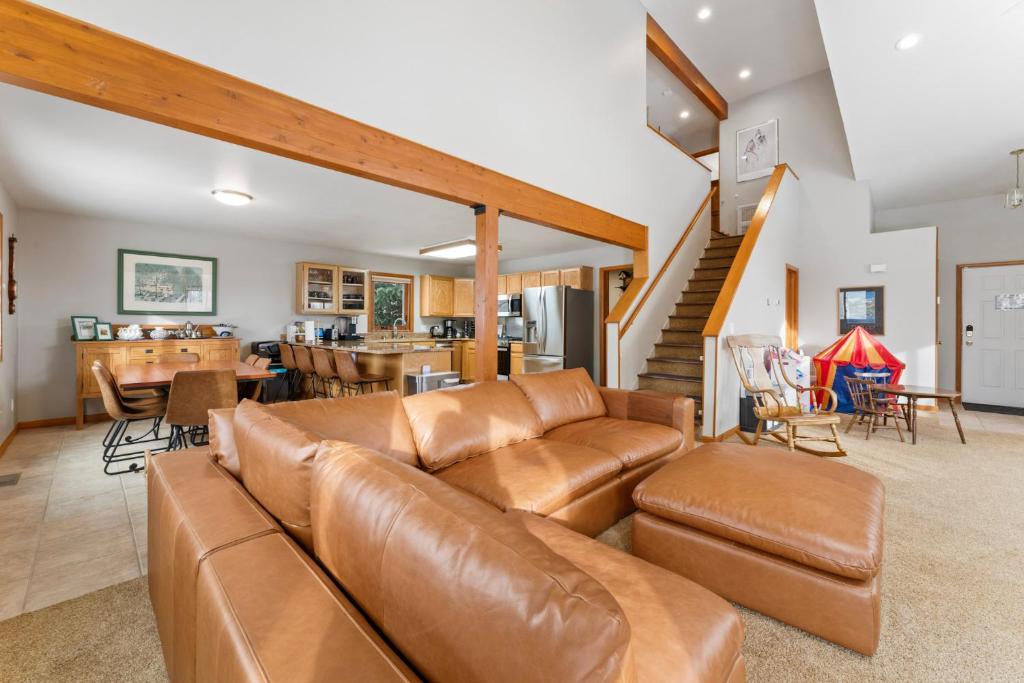 a living room with a brown leather couch and a kitchen at 1101 Mesa Drive: 2 in Silverthorne