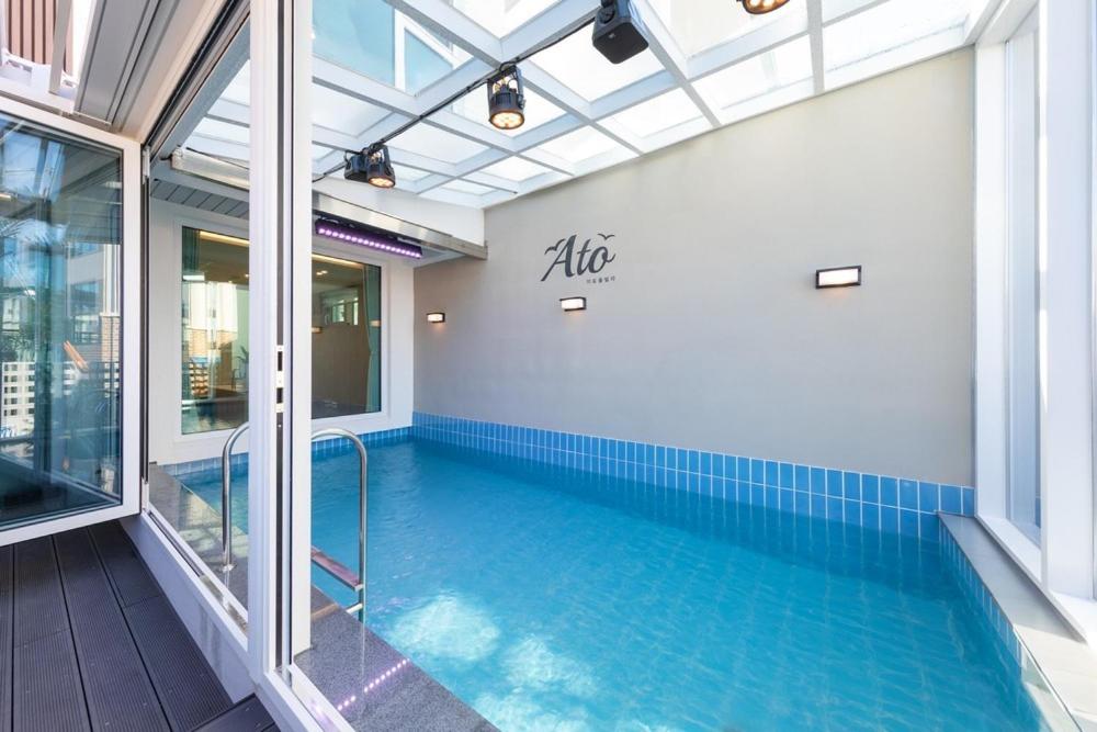 a swimming pool in a building with an indoor swimming pool at Gangneung Atopool Villa in Gangneung