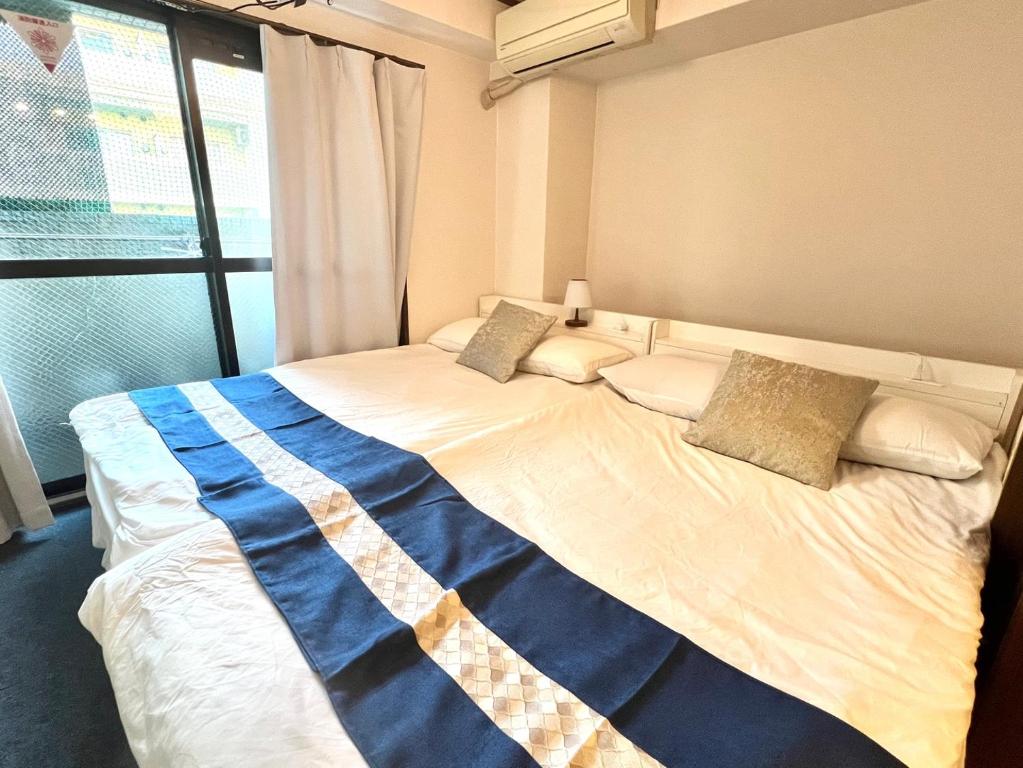 a large bed in a room with a window at 大国町駅徒歩3分 なんば駅1駅 最大6名 ロイヤル601 in Osaka