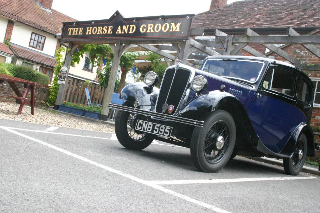 an old blue car parked in a parking lot at Horse & Groom B&B in Westbury