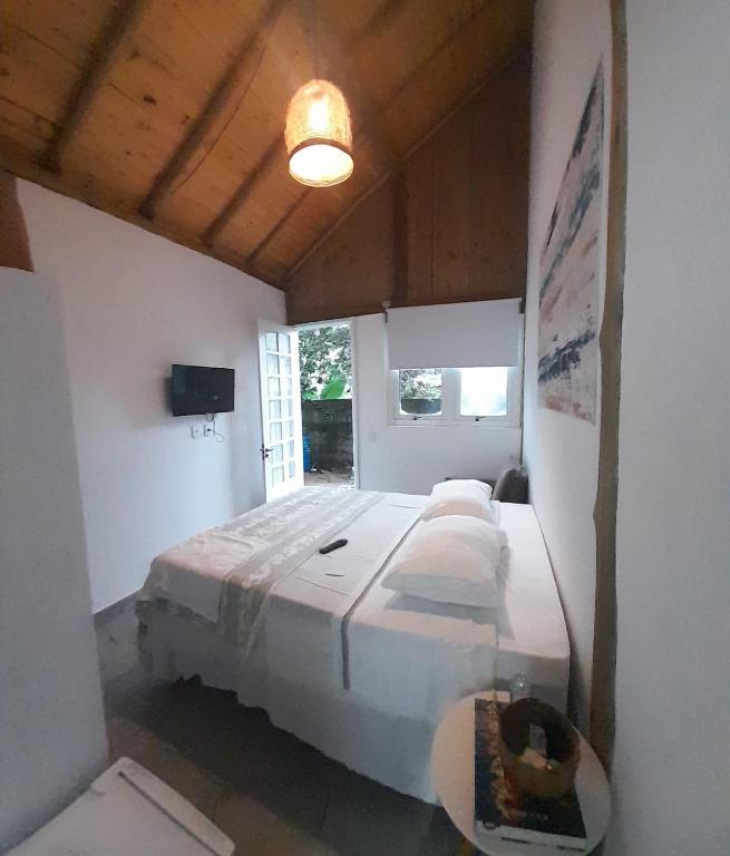 a bedroom with a large bed with white pillows at Suíte Recanto bom Sossego in Ubatuba