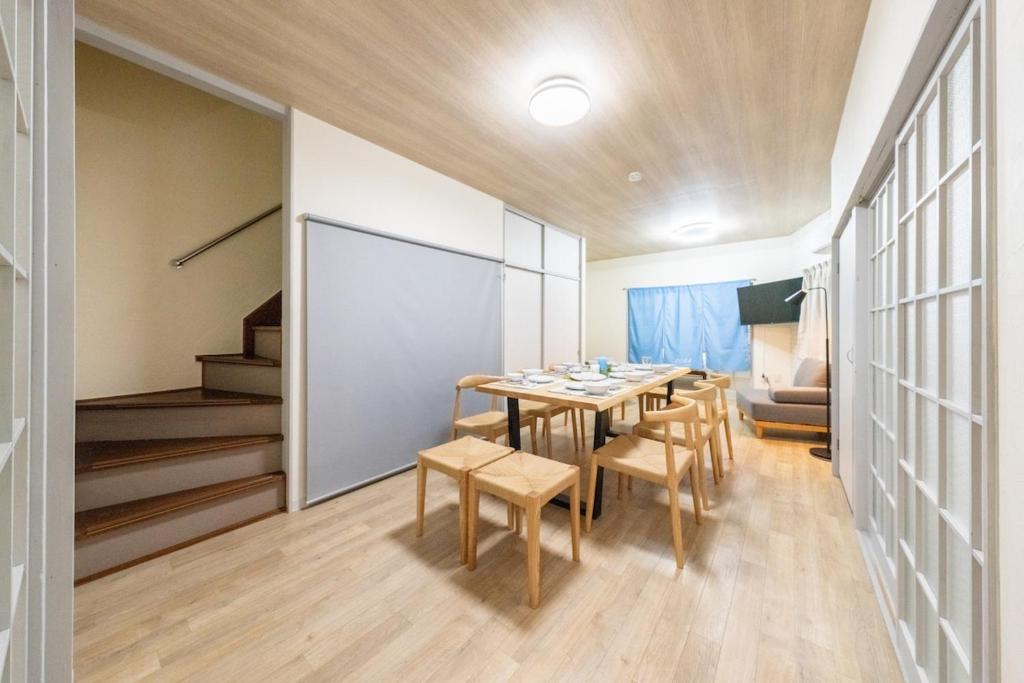 a dining room with a table and chairs at SORA usjまで電車で8分 5つの寝室 貸切の宿で楽しい時間を過ごしてください in Osaka
