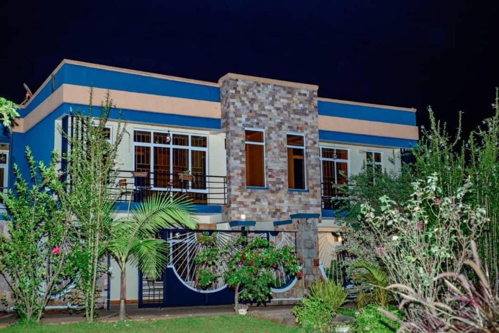 ein blau-weißes Haus mit Garten in der Unterkunft Konga Guesthouse in Kigali