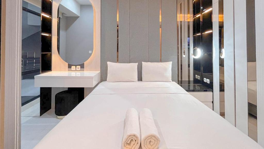 Postel nebo postele na pokoji v ubytování The Luxury Studio at Delft Ciputra Makassar Apartment By Travelio