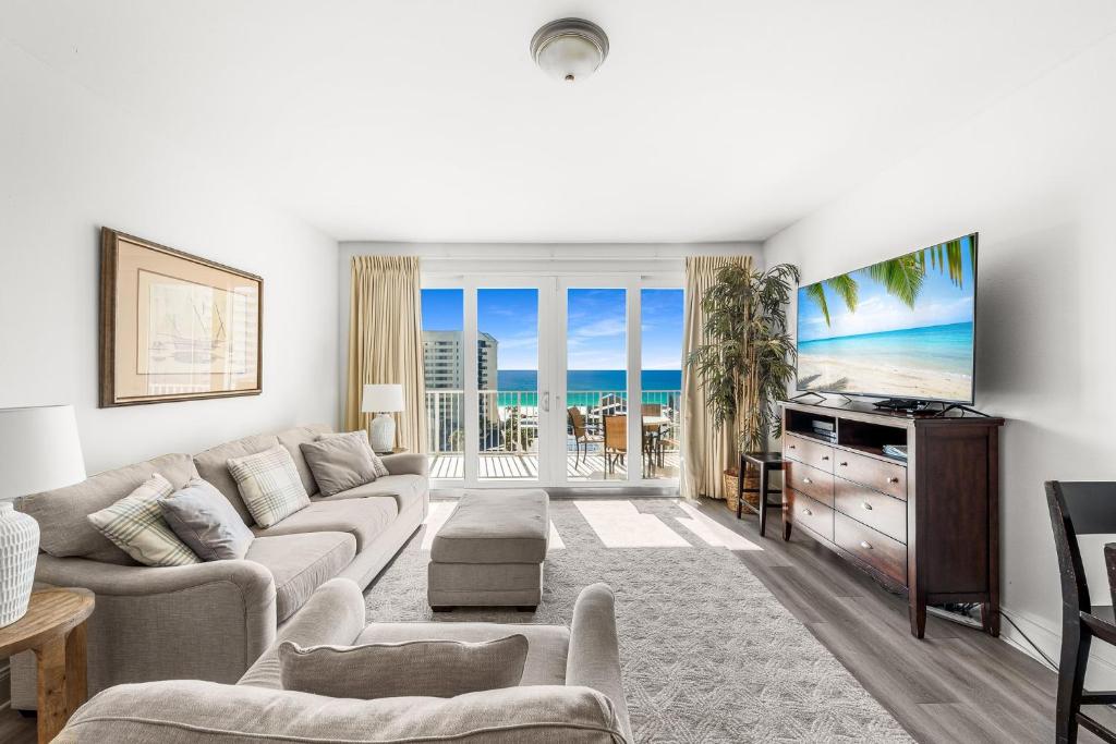 a living room with a couch and a flat screen tv at Amazing Beach Ocean View Condo! Free Beach ChairsService! Sleeps 8! by Dolce Vita Getaways PCB in Panama City Beach