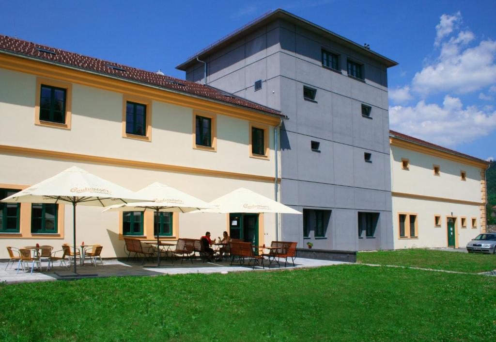 Třemošnice的住宿－Wellness hotel Lihovar，前面有桌子和伞的建筑