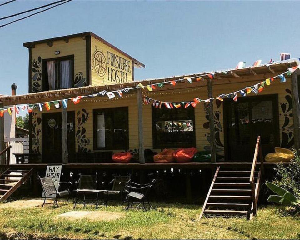 Una casa con una mesa y sillas delante de ella. en Hostel Finisterre, en La Pedrera