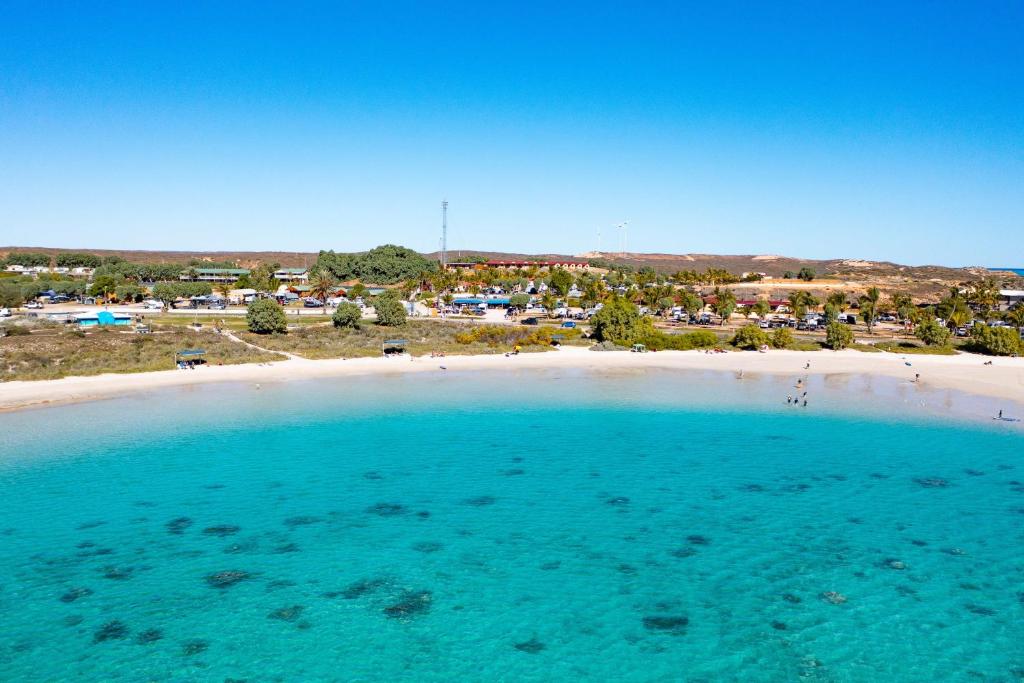 - une vue aérienne sur une plage avec un groupe de tentes dans l'établissement Peoples Park, à Coral Bay