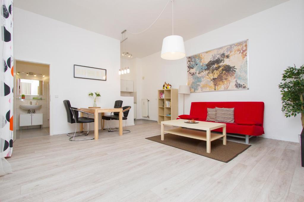 uma sala de estar com um sofá vermelho e uma mesa em Apartment Uthman Berlin-Neukölln em Berlim