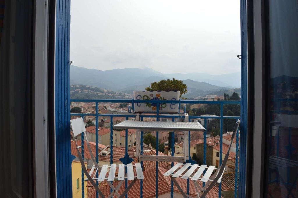 un balcon avec deux chaises et une vue sur une ville dans l'établissement Appart T1 BANYULS SUR MER LA GRANDE BLEUE BN410-023, à Banyuls-sur-Mer