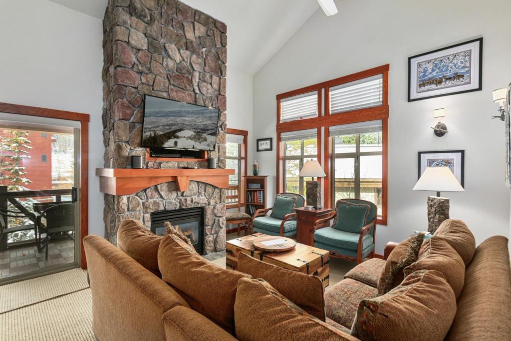 - un salon avec des canapés et une cheminée en pierre dans l'établissement 1311 - Three Bedroom Deluxe Eagle Springs West condo, à Solitude