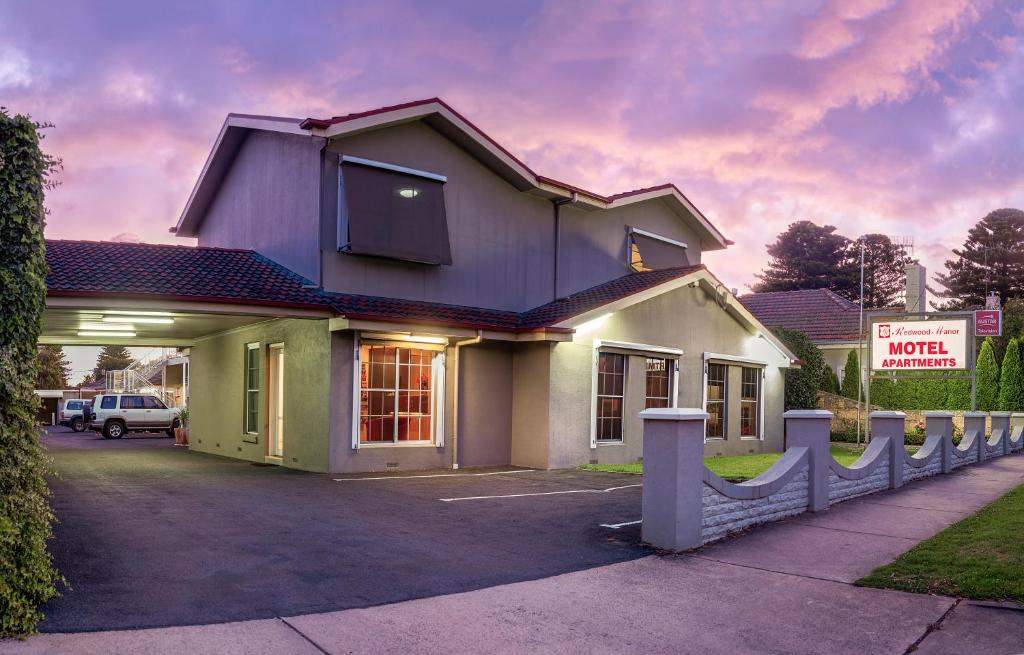 a house with a sign in front of it at Redwood Manor Motel Apartments in Warrnambool