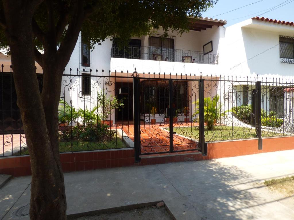 a fence in front of a house with a building at Hostal Mizare Valledupar in Valledupar