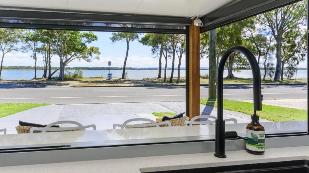 cocina con fregadero y vistas al agua en 'bribie Beach Apartment', en Bellara