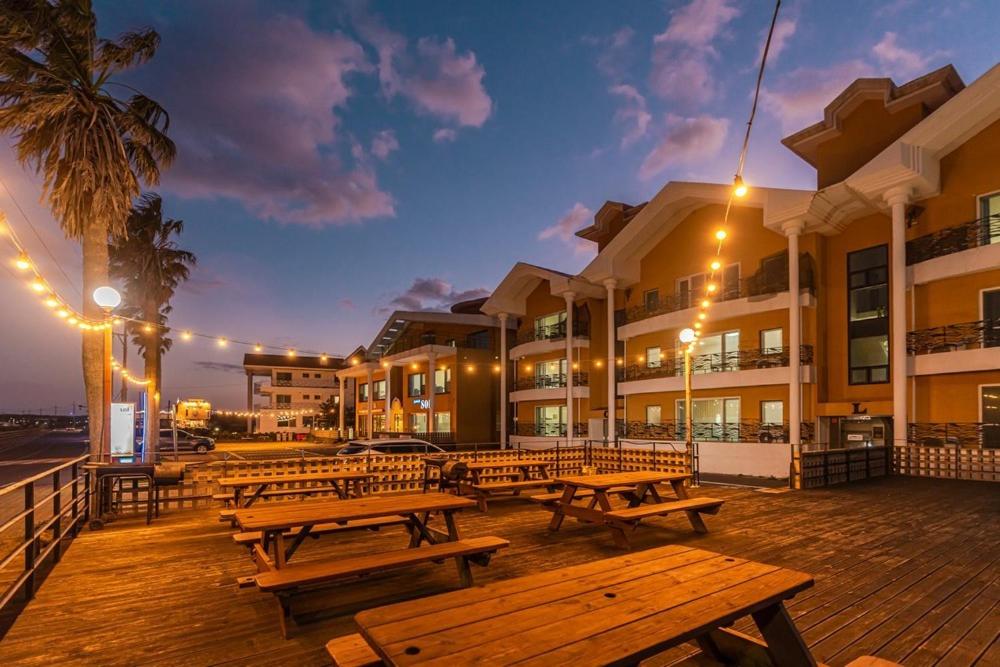 a group of benches on a boardwalk near a building at Jeju Sol Pension Jeju Sunrise from the Room in Chung-dong