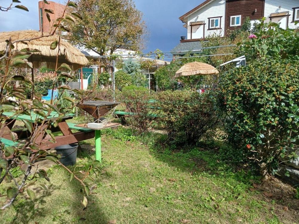 a garden with a picnic table and a house at Pohang Mimi House Pension in Pohang