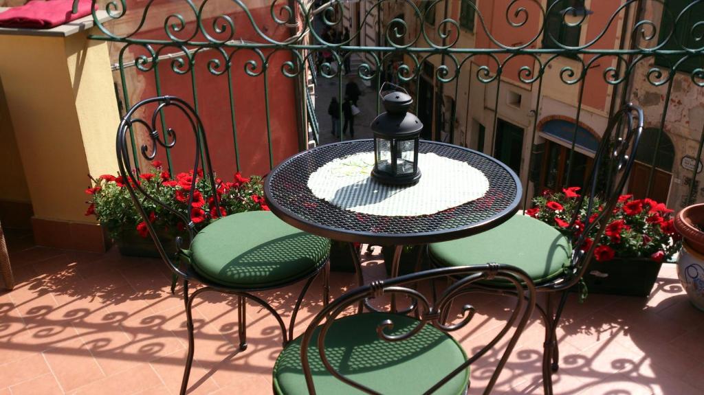een tafel met stoelen en een lantaarn op een patio bij L'Antica Terrazza in Monterosso al Mare
