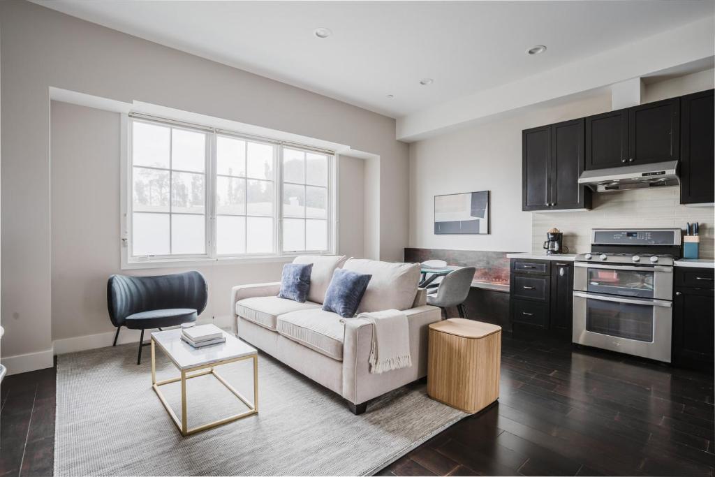 a living room with a couch and a kitchen at Blueground Burlingame ac wd nr park SFO-1791 in San Francisco