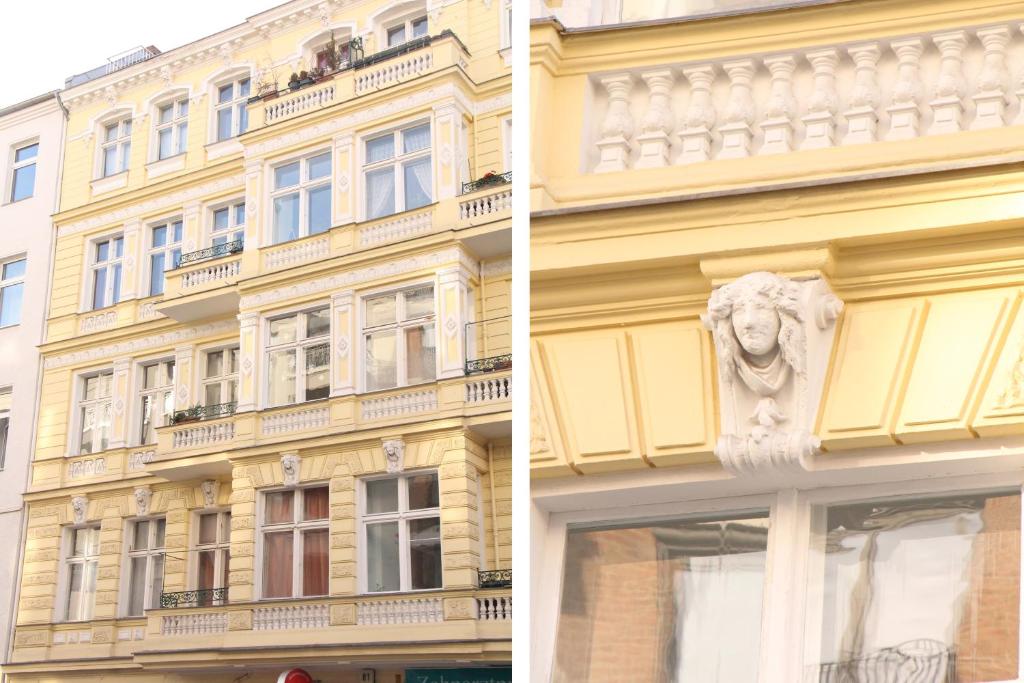 un edificio amarillo con una estatua delante de él en Stars Berlin Apartments Zillestraße, en Berlín