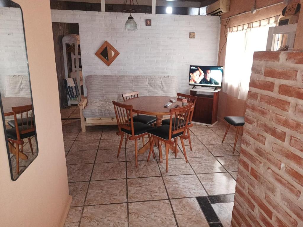 a dining room with a table and chairs and a tv at La casita en San Miguel del Monte in San Miguel del Monte