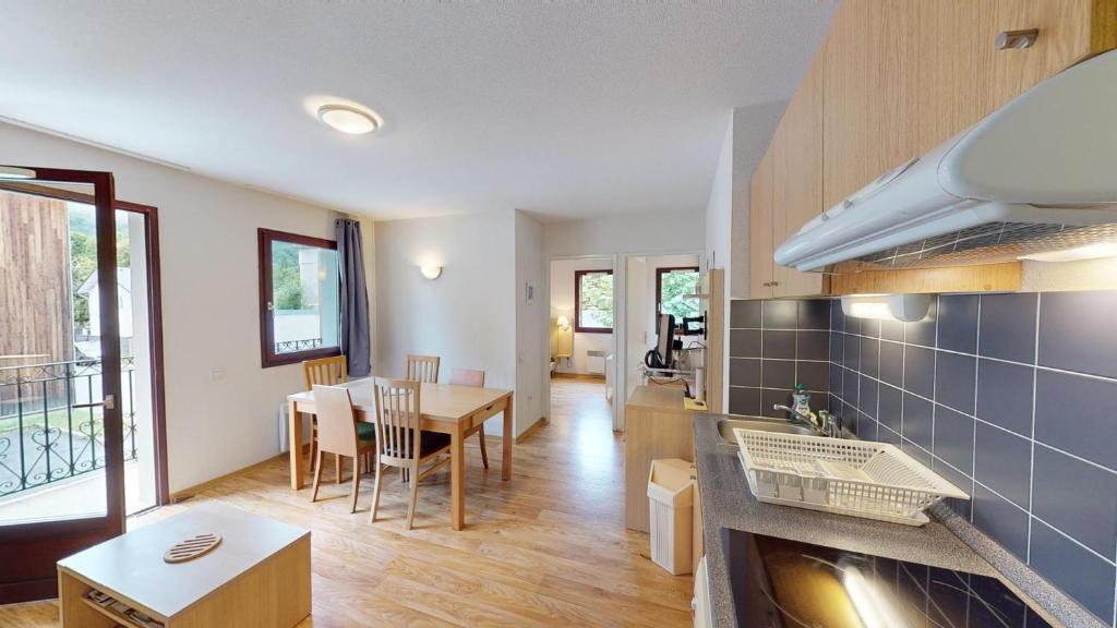 une cuisine et une salle à manger avec une table et des chaises dans l'établissement Apartamento Jardins de Ramel, à Luchon