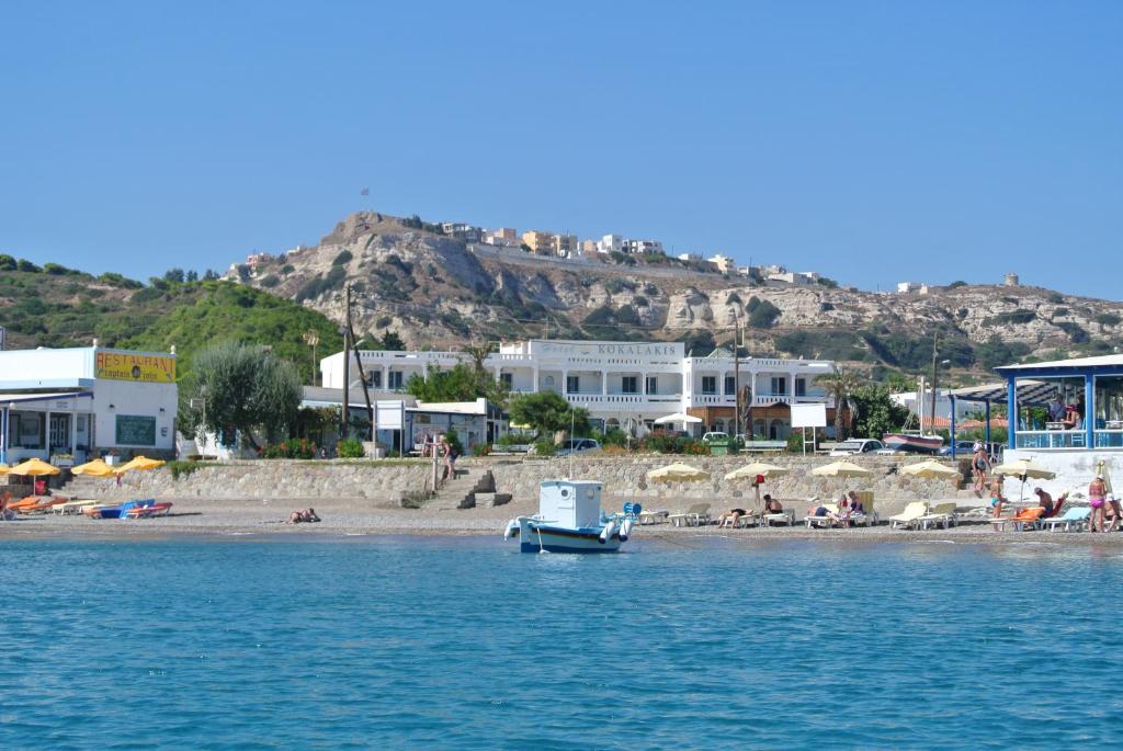 a boat sitting on top of a beach next to a body of water at Kokalakis Hotel in Kefalos