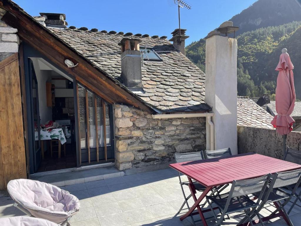 une maison avec une table et des chaises sur une terrasse dans l'établissement Gîte Gîte Brager 2/4 personnes à Ispagnac, à Ispagnac