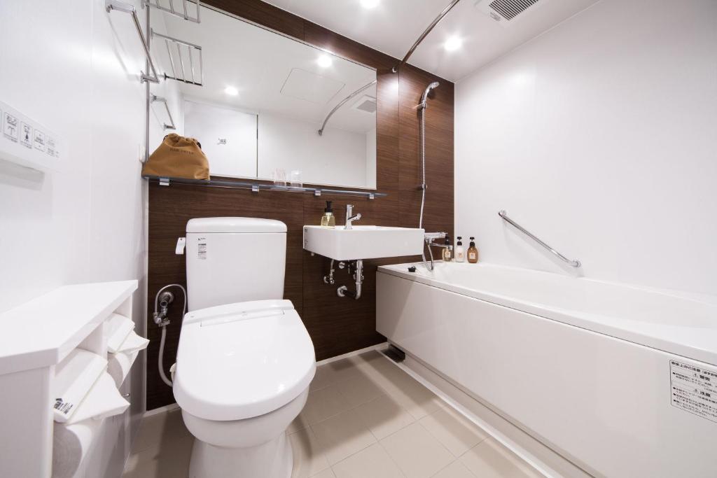 a bathroom with a white toilet and a sink at HOTEL MYSTAYS PREMIER Kanazawa in Kanazawa