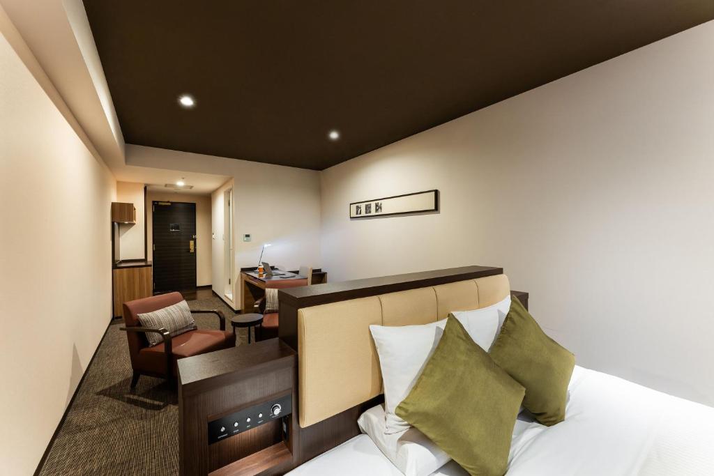 a hotel room with a bed and a desk at HOTEL MYSTAYS PREMIER Kanazawa in Kanazawa