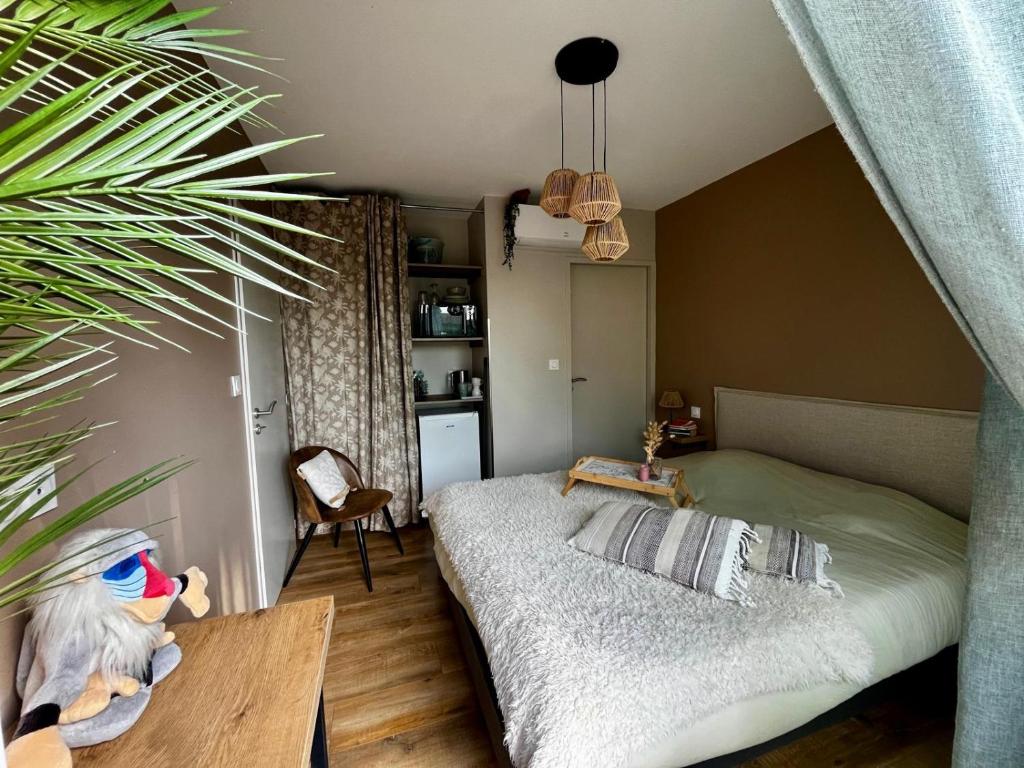 - une chambre avec un lit, une table et une plante dans l'établissement Sun Oasis Suite Parentale, à Bretignolles-sur-Mer