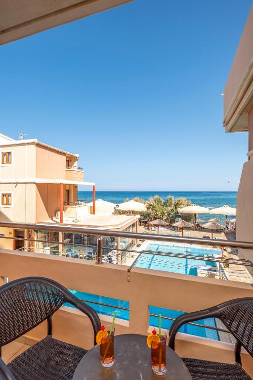 balkon z widokiem na basen i ocean w obiekcie Kato Stalos Mare w Stalós