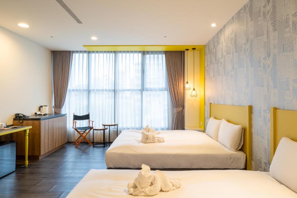 a hotel room with two beds with towels on them at 凝萃文旅 台中車站店 NCH-Business Hotel in Taichung