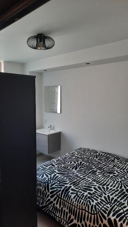 a bedroom with a black and white bed and a sink at Chambre d'hôte, la b&w in Liège