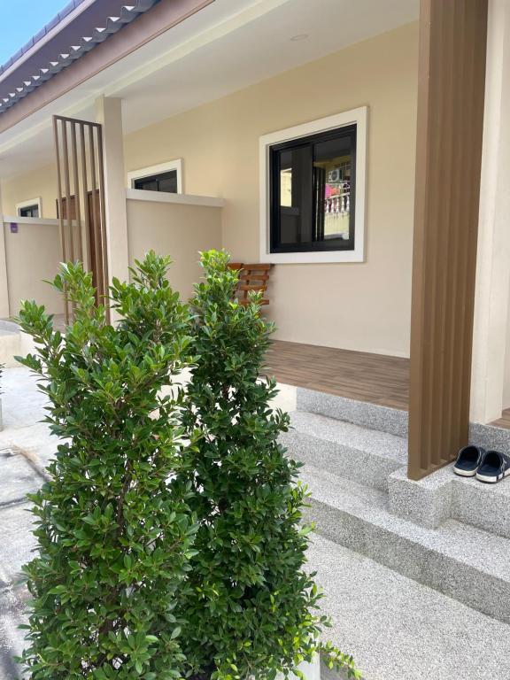 two bushes in front of a house at Apartement 28 Stay High in Thongsala