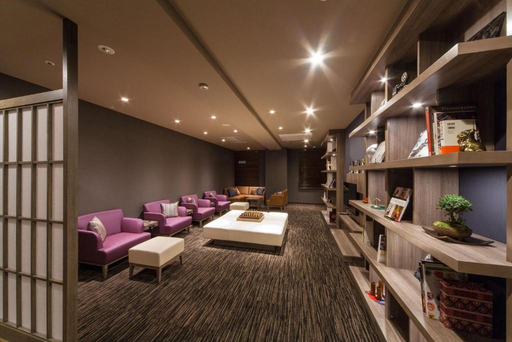 a waiting room with purple chairs and a table at HOTEL MYSTAYS PREMIER Kanazawa in Kanazawa