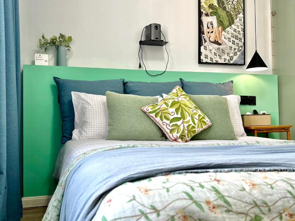 a bedroom with a blue and green bed with pillows at Shanghai Guiwu Village Near Disney Resort in Shanghai